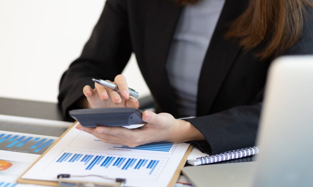 Financial planning and expense accounting, analyzing a business account report using a calculator.